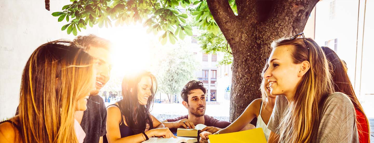 Group of Students working outside on a table under tree