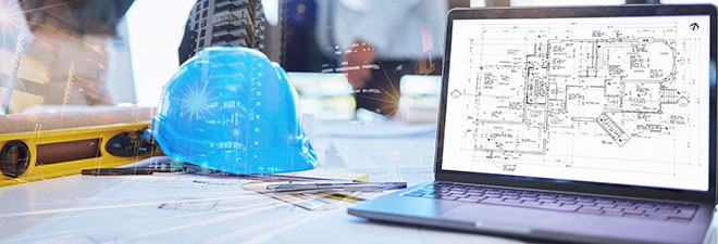 Hard hat and laptop with building plans