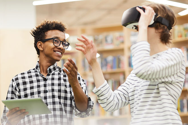 Students in a library using a VR headset