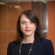 A headshot of Josephine Jackson against a blurred brown background.